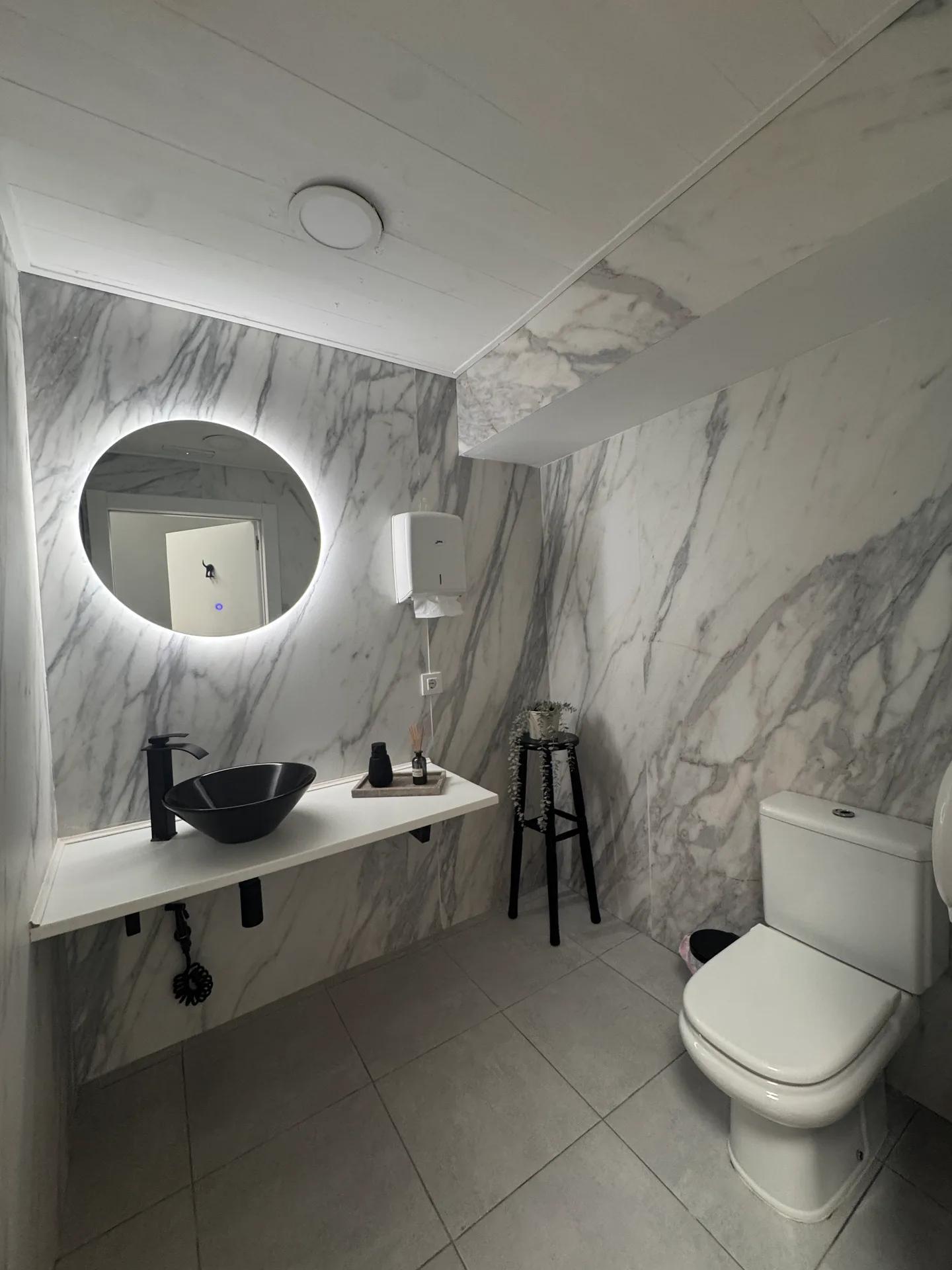 Baño de mármol blanco de Eclipse Studio con espejo retroiluminado