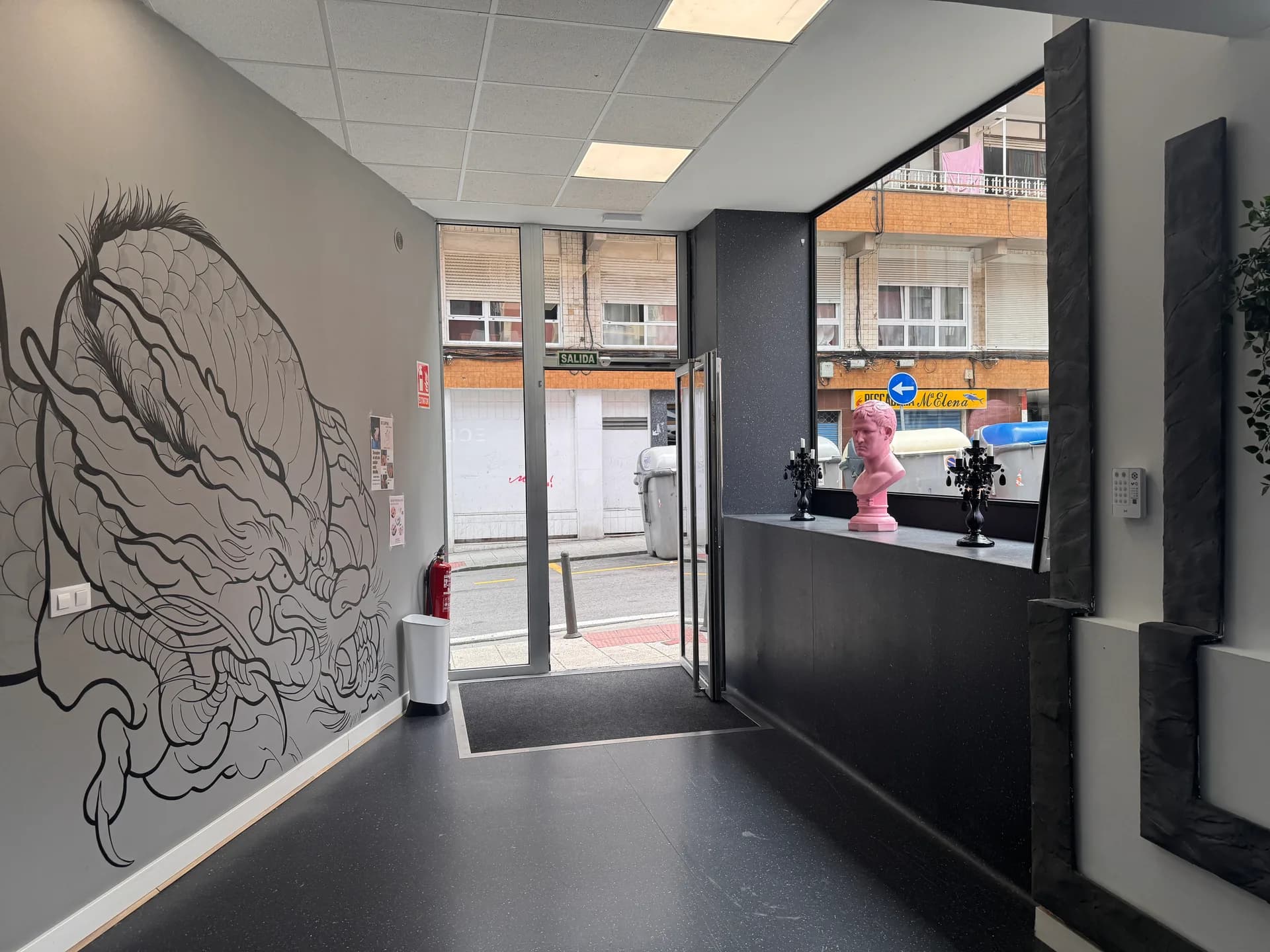 Entrada de Eclipse Studio con mural, busto rosa y candelabros en recepción