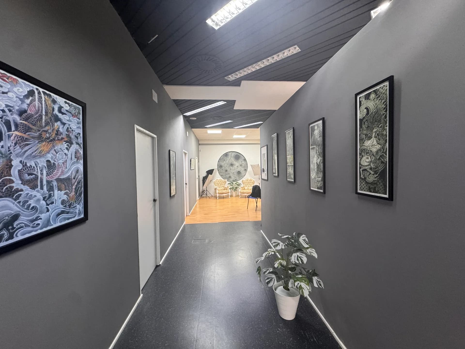 Pasillo de Eclipse Studio con cuadros de tatuaje y sala de espera al fondo